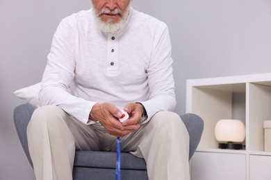 Photo of Senior man pressing emergency call button at home, closeup