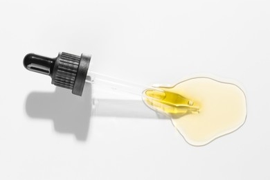 Photo of Cosmetic oil and pipette on light grey background, top view