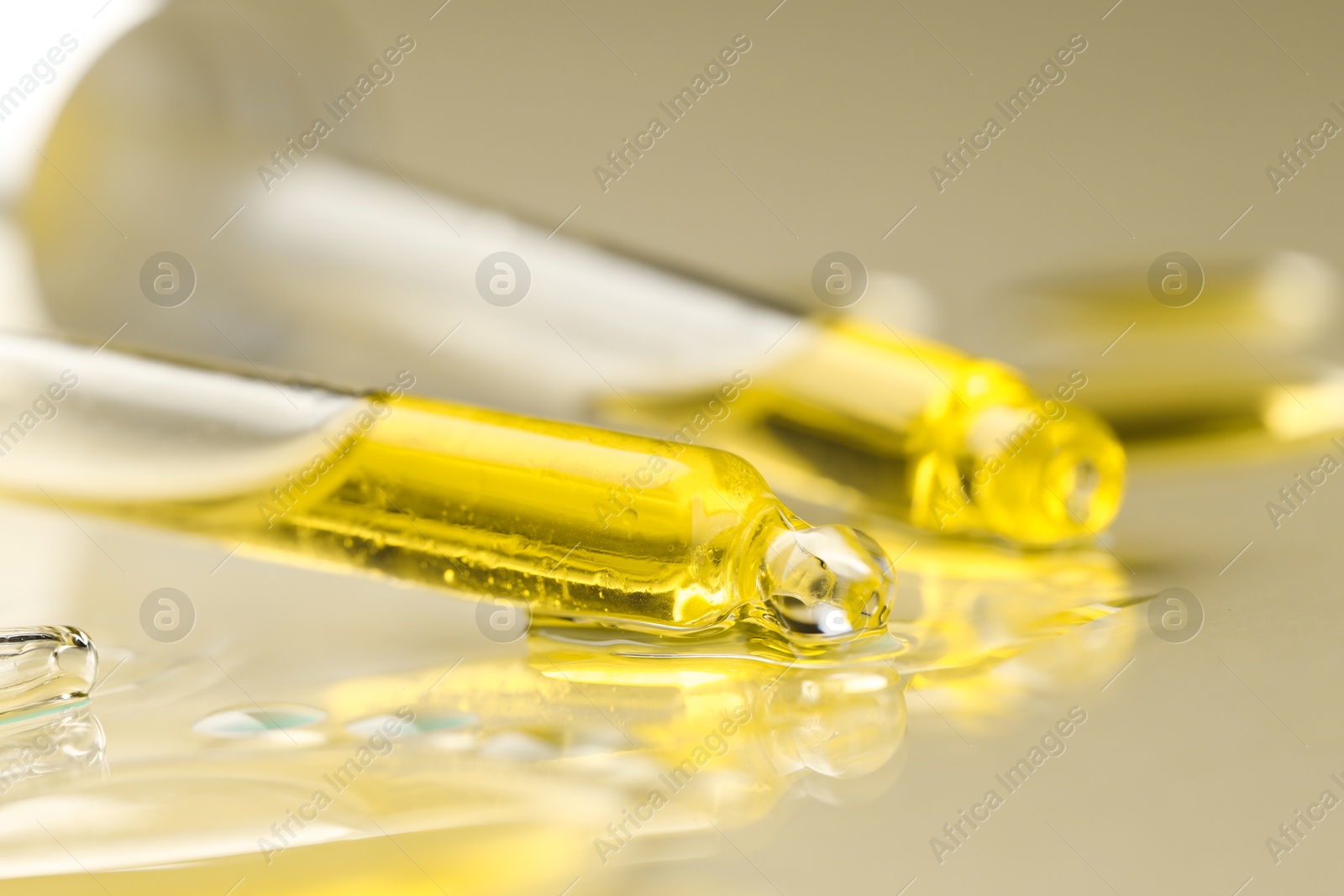 Photo of Cosmetic oil and pipettes on dark beige background, closeup