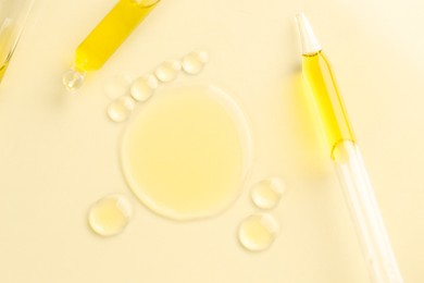 Photo of Cosmetic oil and pipettes on dark beige background, flat lay