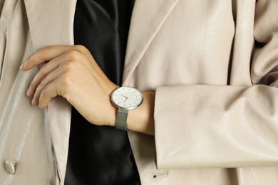 Photo of Beautiful woman in stylish beige jacket and watch, closeup