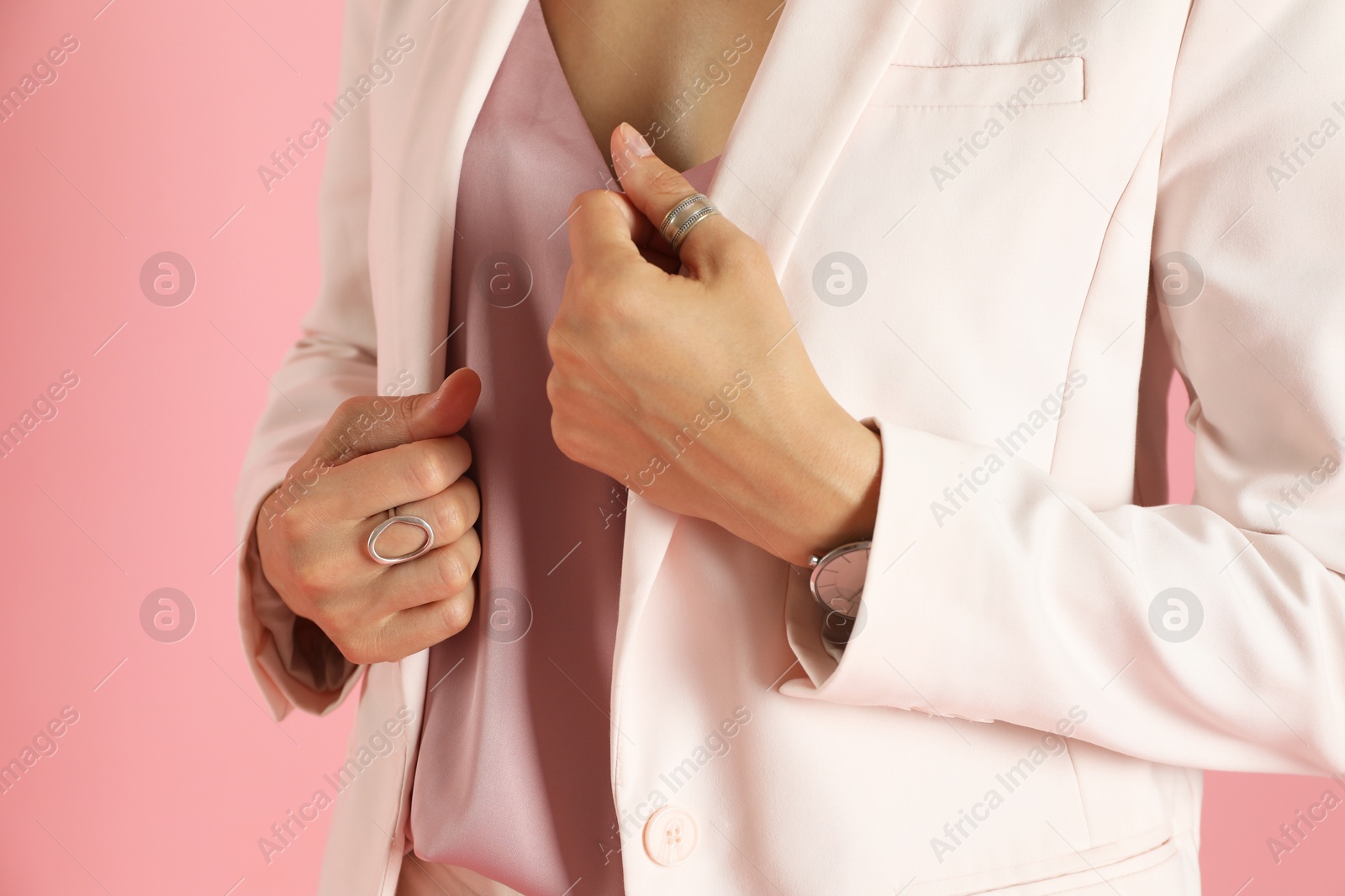 Photo of Beautiful woman in stylish white suit on pink background, closeup