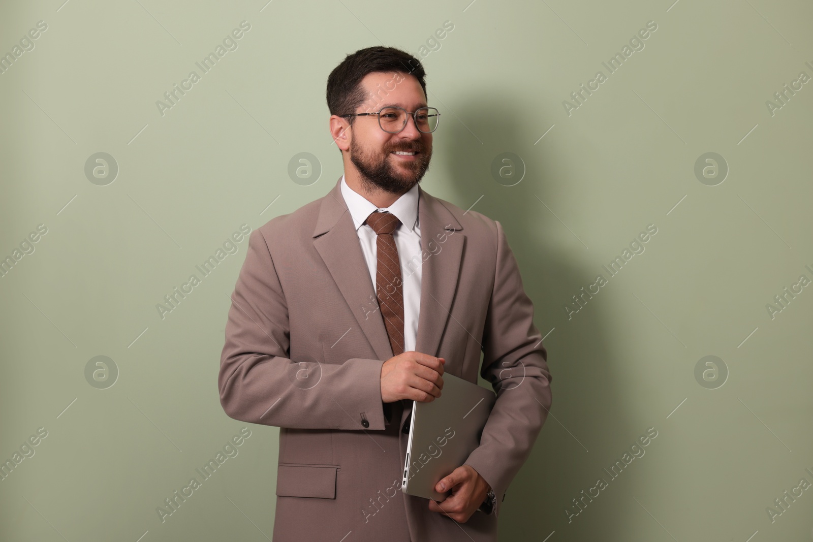 Photo of Smiling businessman with laptop on green background