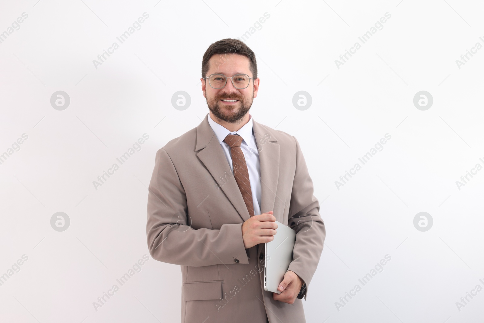 Photo of Portrait of smiling businessman with laptop on light background