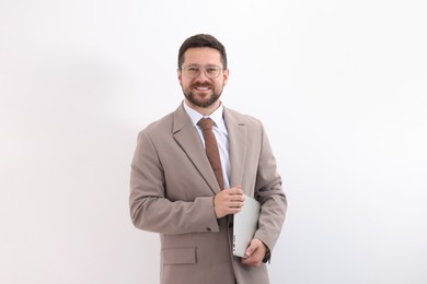 Photo of Portrait of smiling businessman with laptop on light background