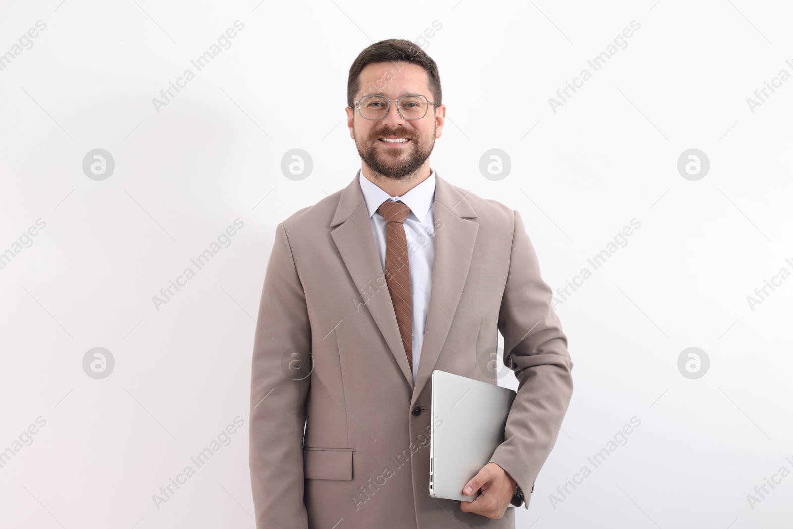 Photo of Portrait of smiling businessman with laptop on light background