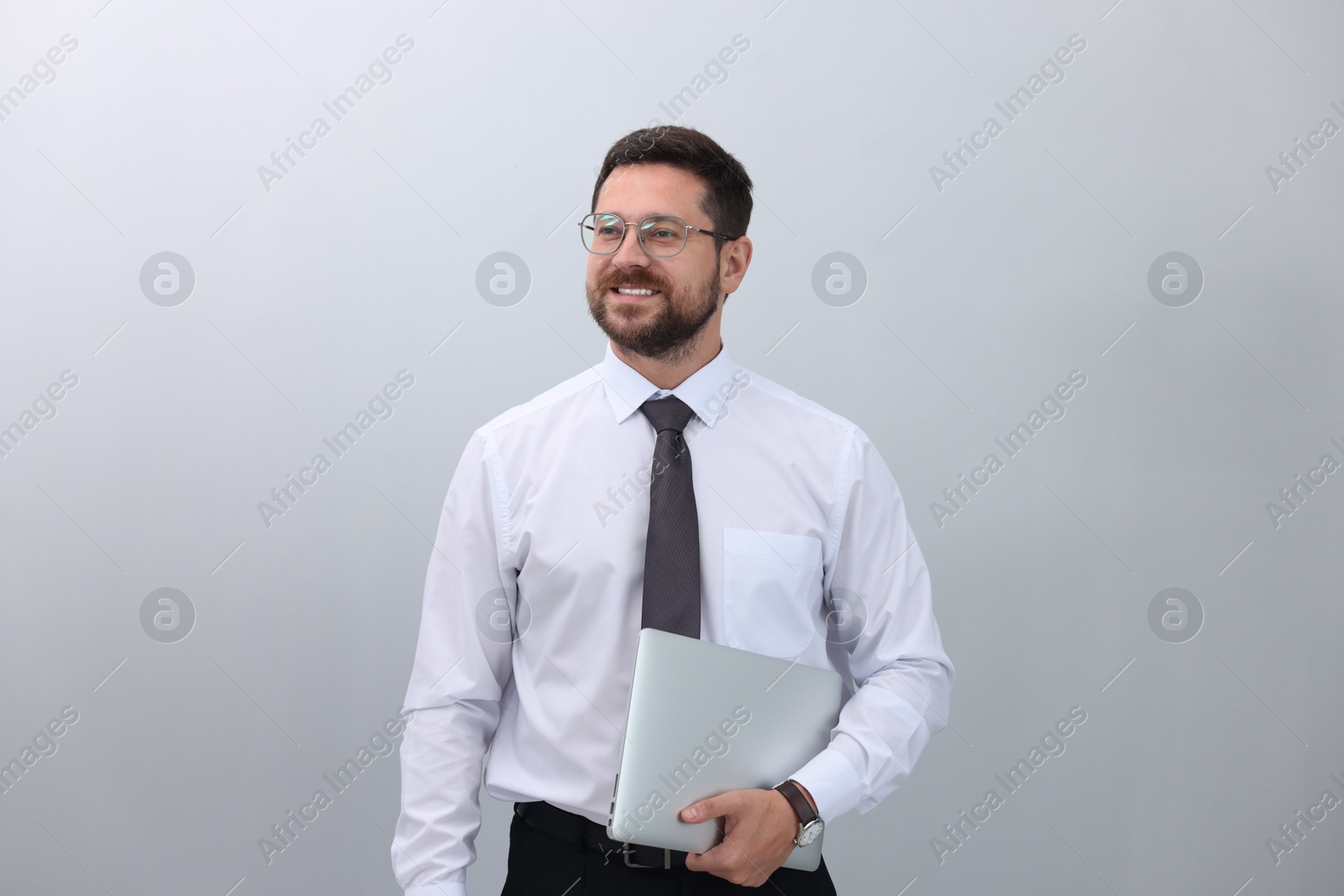 Photo of Portrait of smiling businessman with laptop on white background