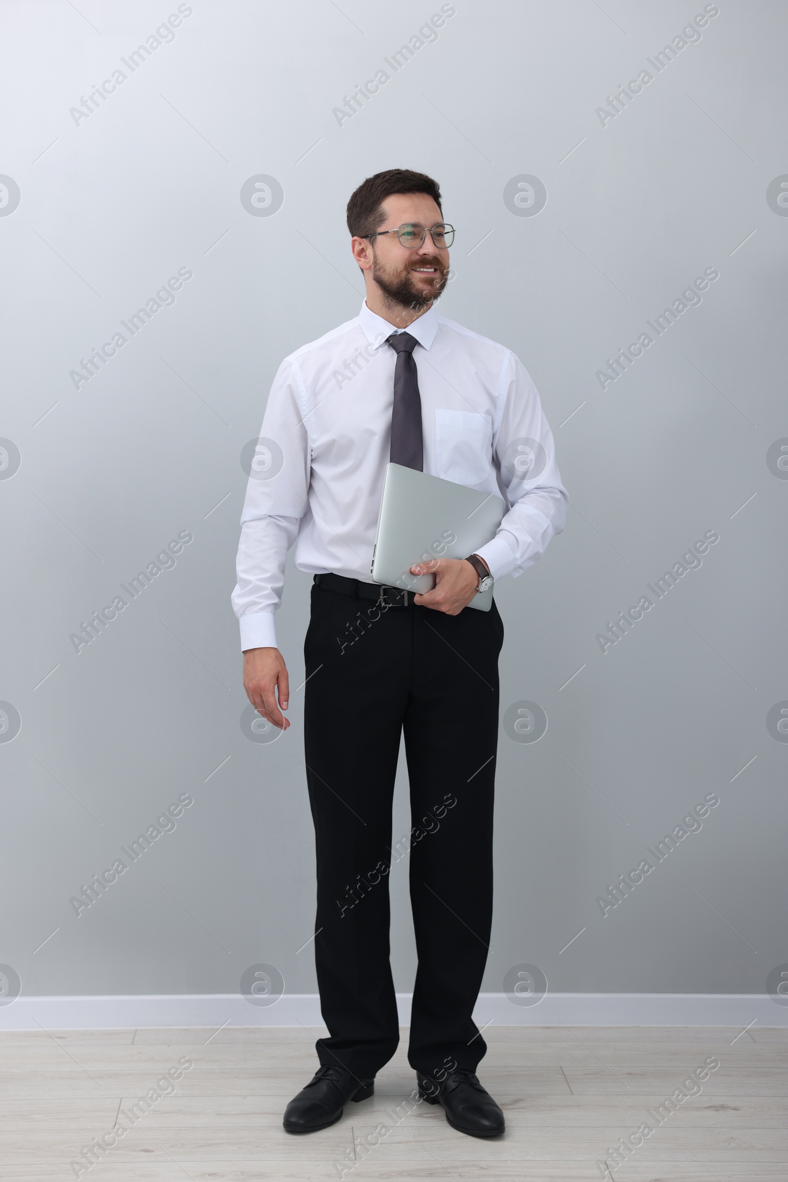 Photo of Smiling businessman with laptop on white background