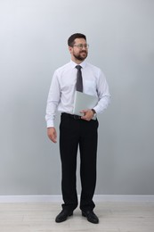 Smiling businessman with laptop on white background