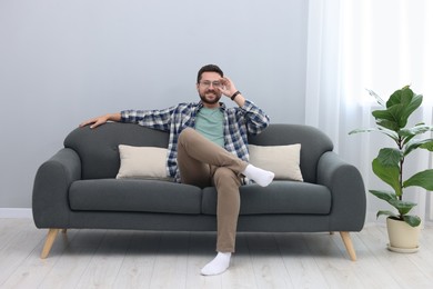 Photo of Smiling man relaxing on sofa at home