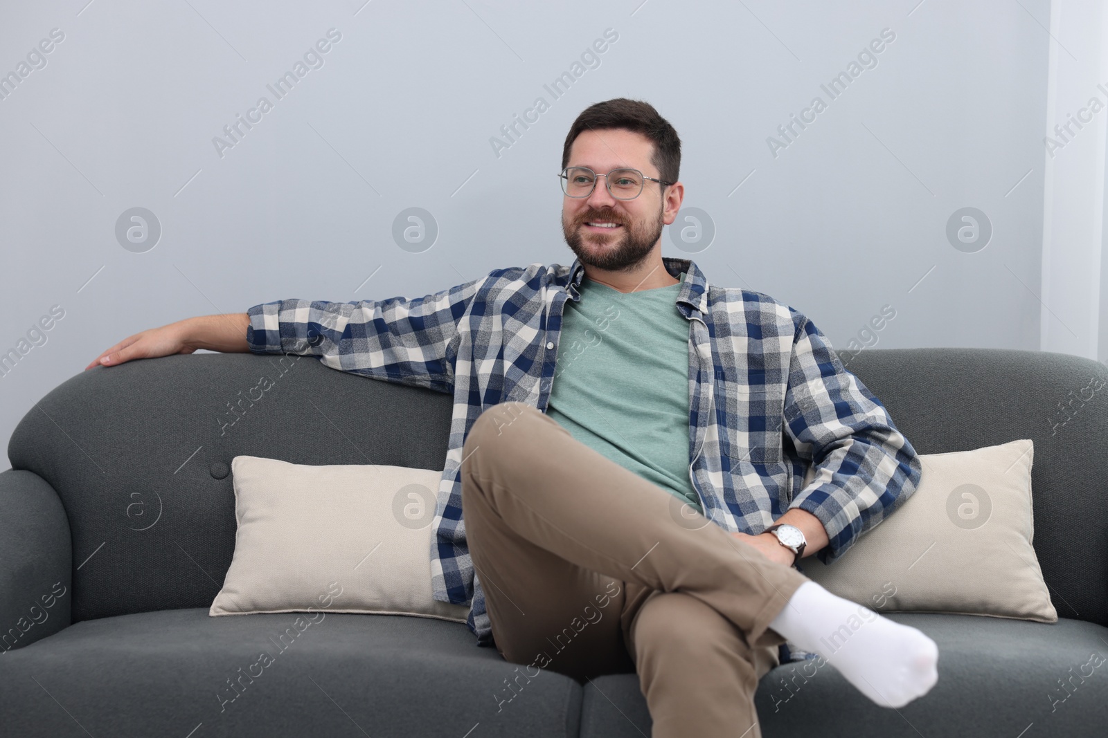 Photo of Smiling man relaxing on sofa at home