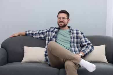 Smiling man relaxing on sofa at home