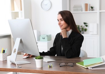 Photo of Smiling businesswoman working at table in office