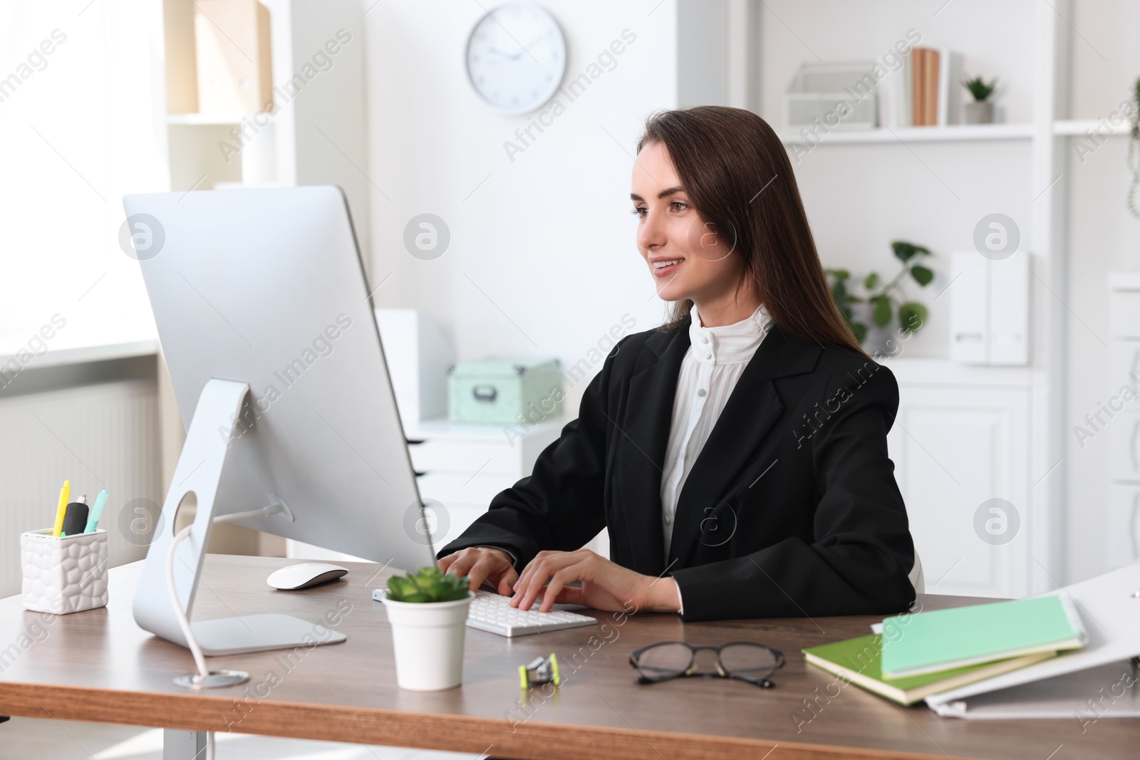 Photo of Smiling businesswoman working at table in office