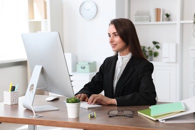 Smiling businesswoman working at table in office