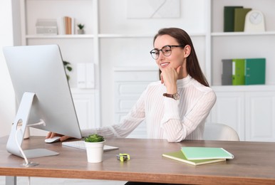 Photo of Smiling businesswoman working at table in office