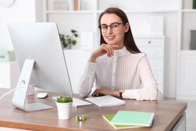 Photo of Portrait of smiling businesswoman at table in office