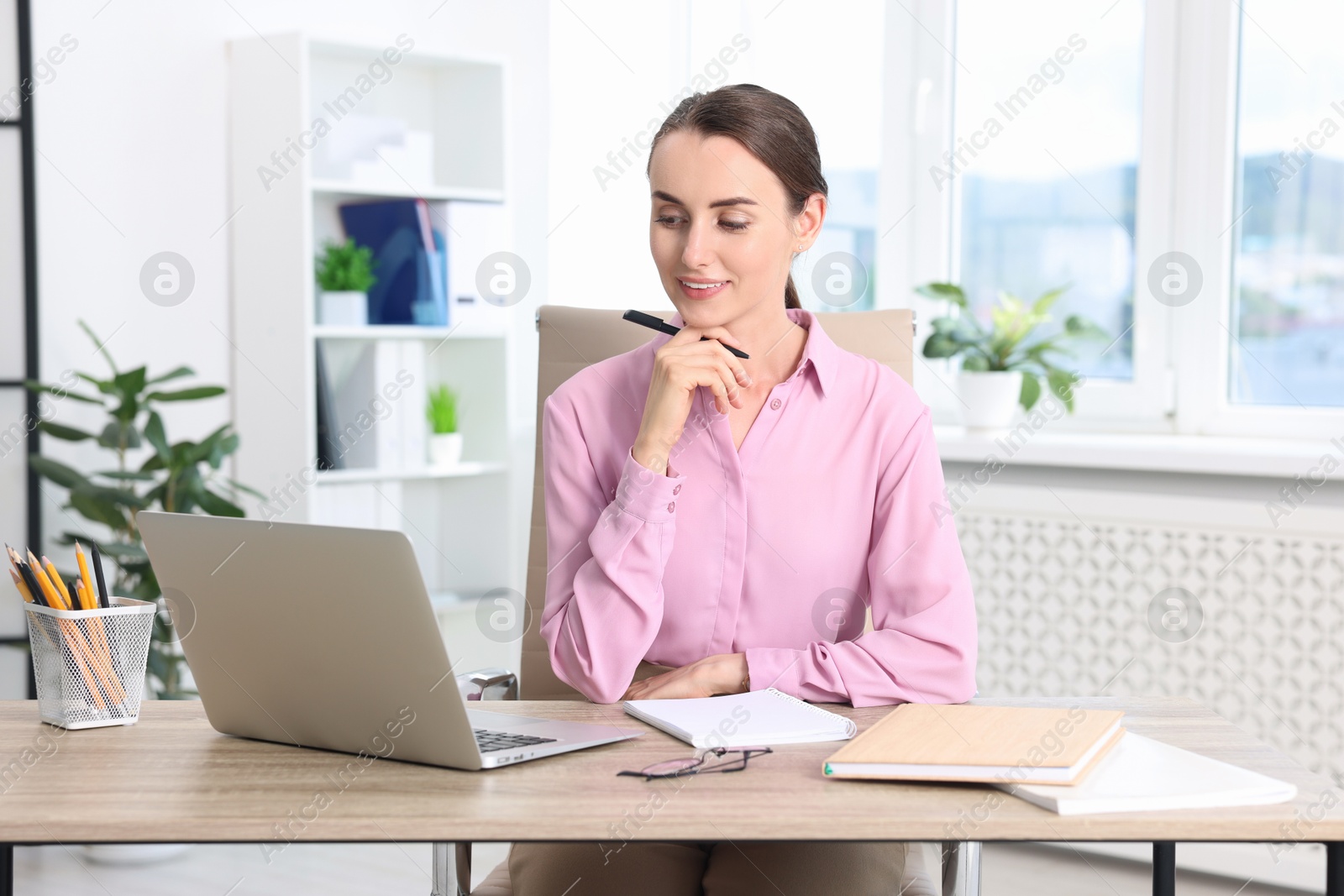 Photo of Smiling businesswoman working at table in office