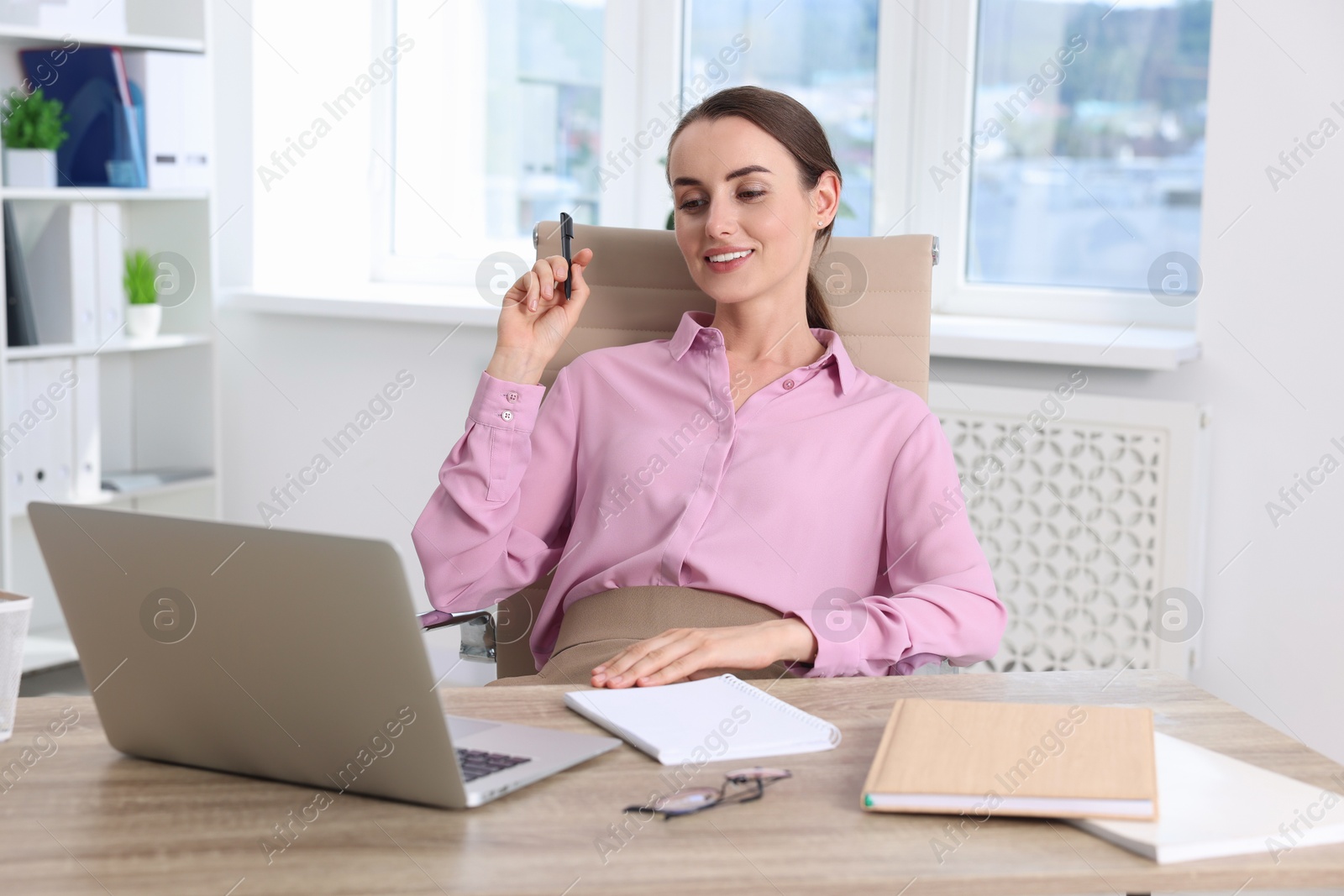 Photo of Portrait of smiling businesswoman at table in office