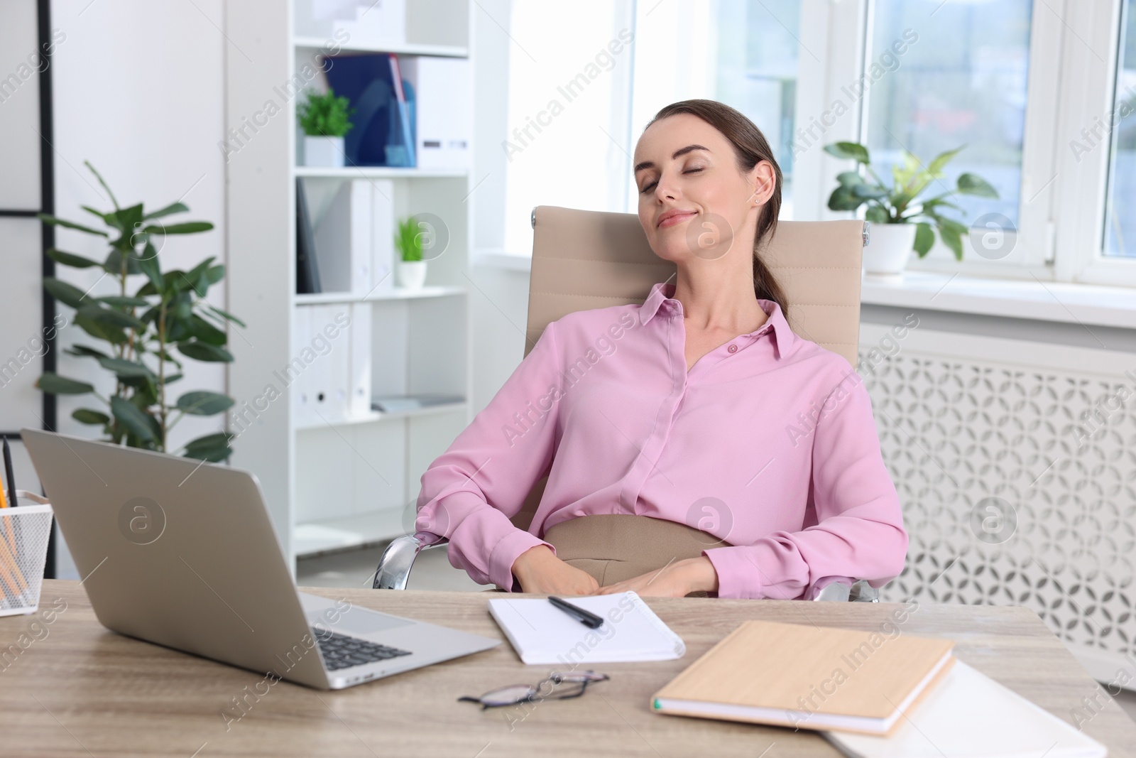 Photo of Beautiful businesswoman relaxing on chair in office. Break time