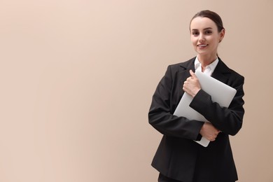 Photo of Portrait of smiling businesswoman with laptop on beige background. Space for text