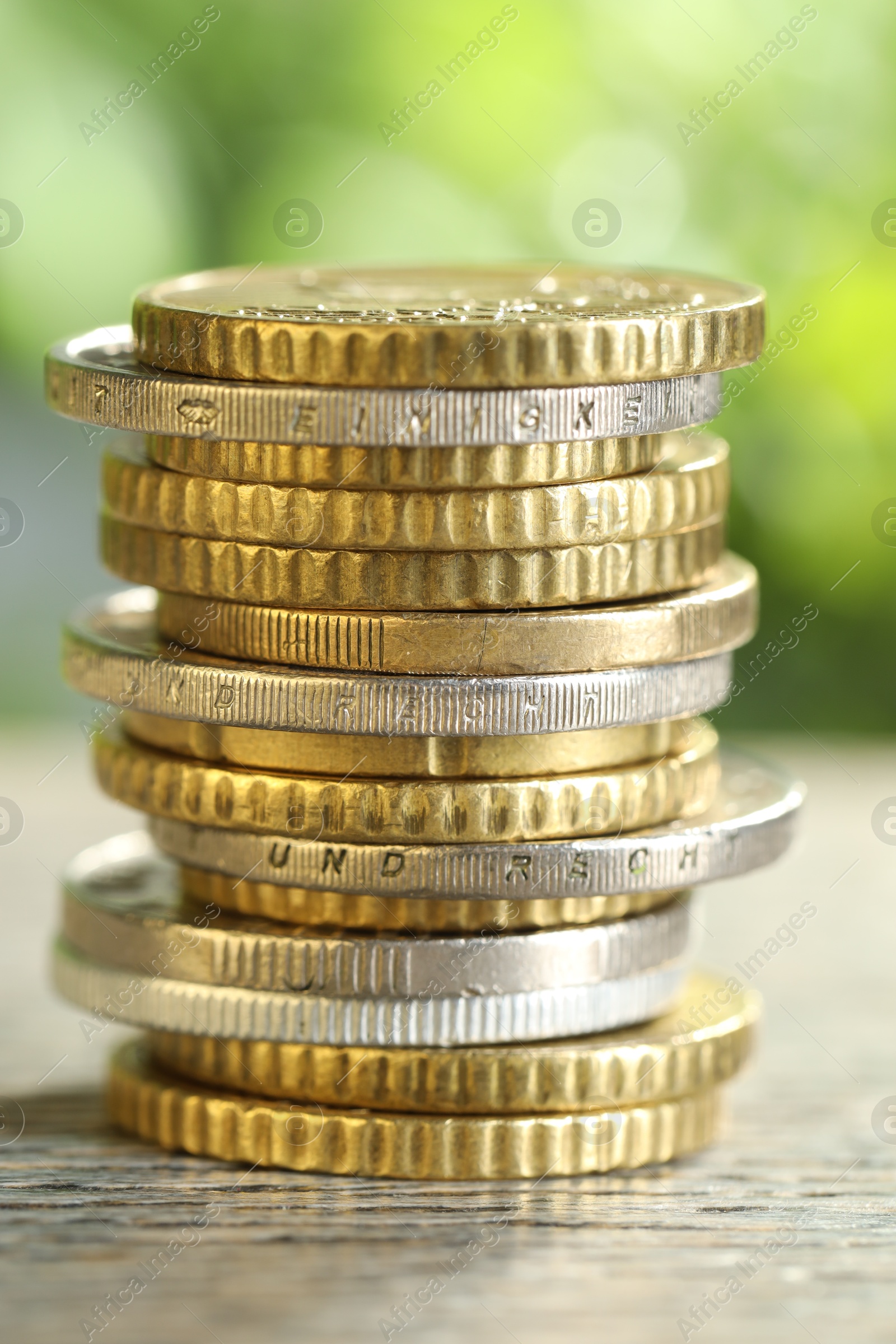 Photo of Salary concept. Stacked coins on grey table against blurred background, closeup