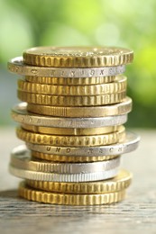 Photo of Salary concept. Stacked coins on grey table against blurred background, closeup