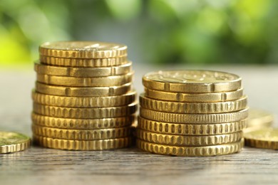 Photo of Salary concept. Stacked coins on grey table against blurred background, closeup