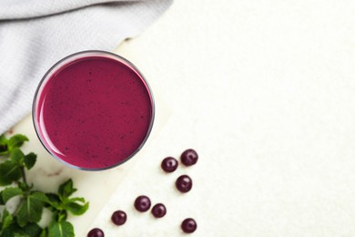 Tasty fresh acai juice in glass on light table, top view. Space for text