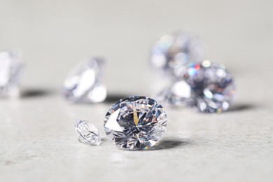 Photo of Many beautiful shiny diamonds on light background, closeup