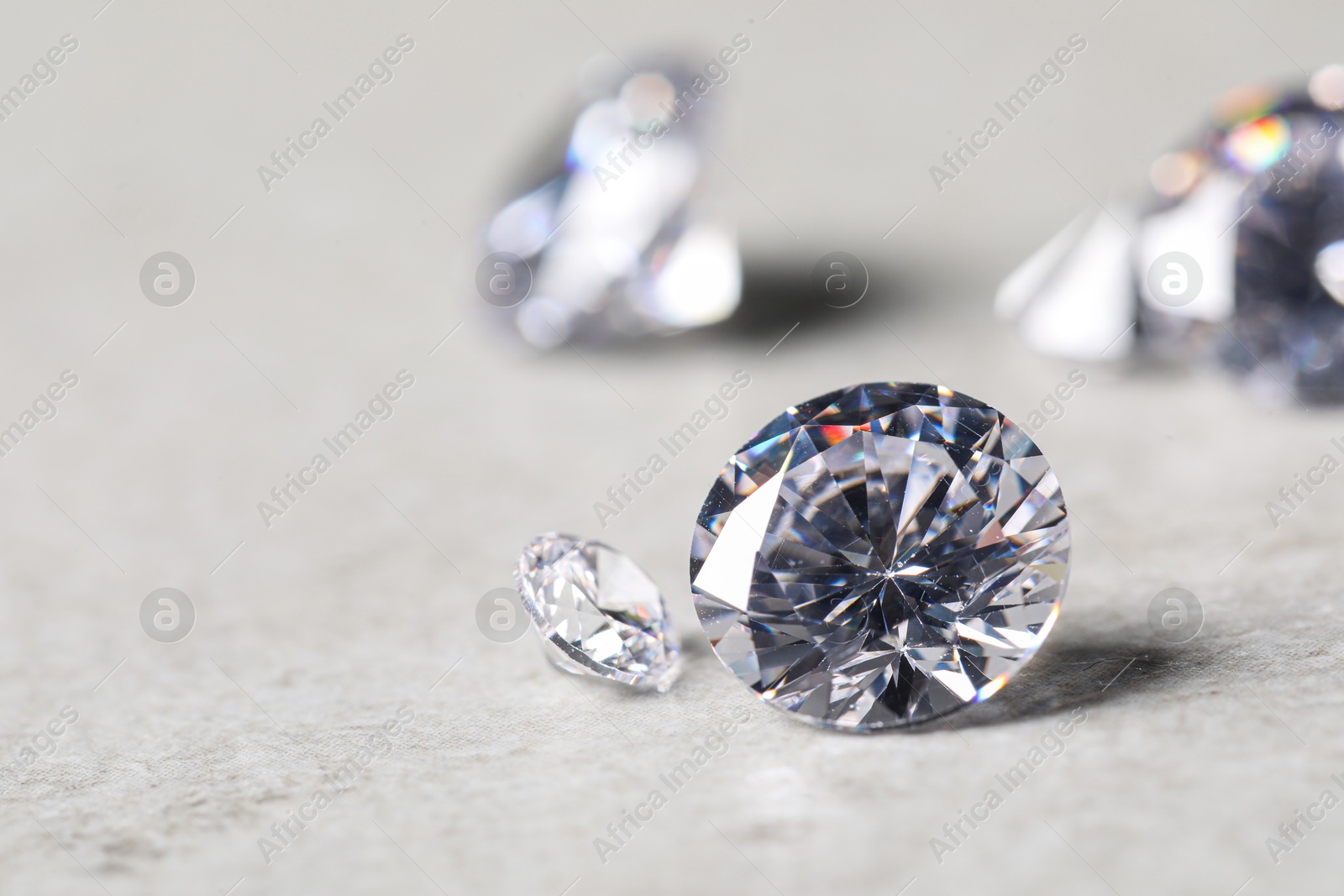 Photo of Many beautiful shiny diamonds on light background, closeup