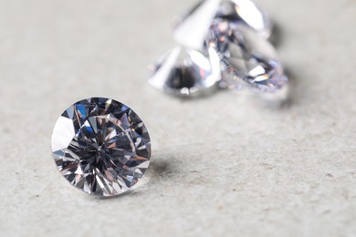 Many beautiful shiny diamonds on light background, closeup