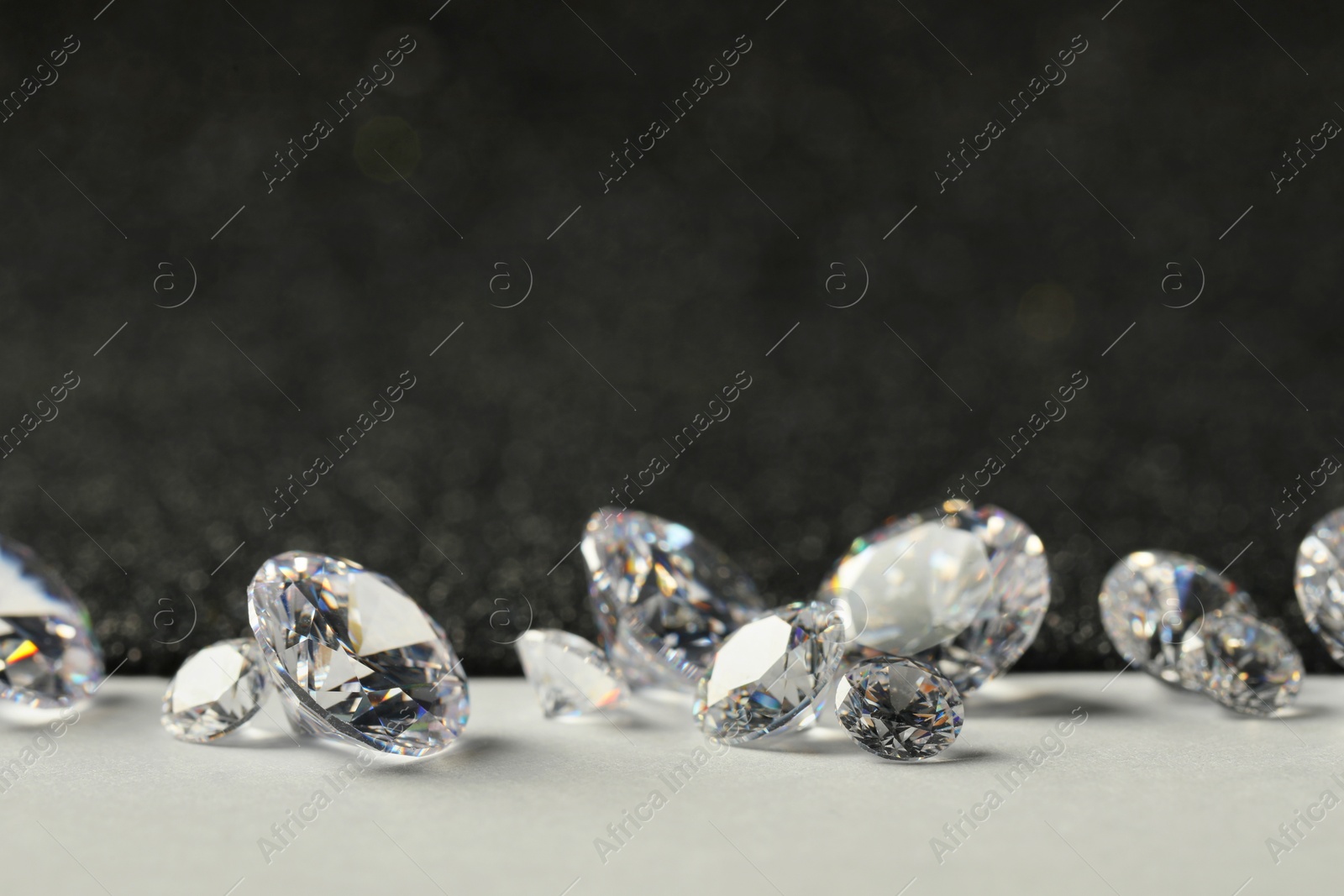 Photo of Beautiful dazzling diamonds on light grey table, closeup