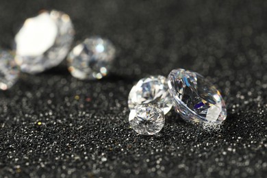 Photo of Beautiful dazzling diamonds on dark shiny background, closeup