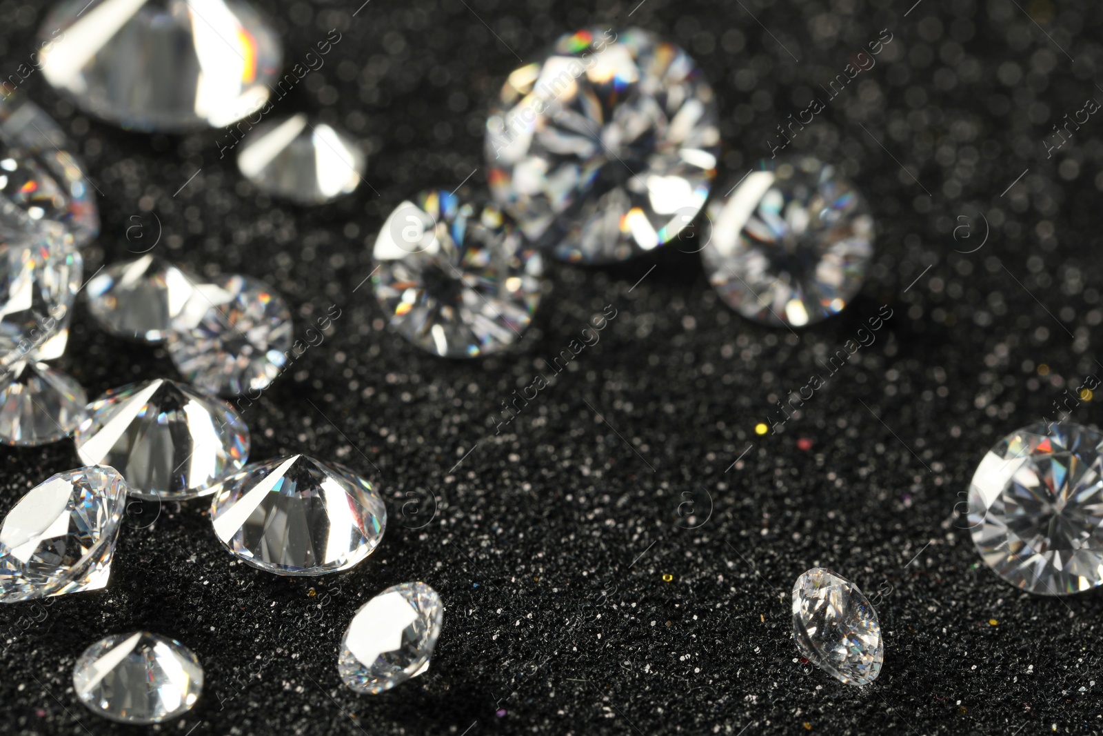 Photo of Beautiful dazzling diamonds on dark shiny background, closeup