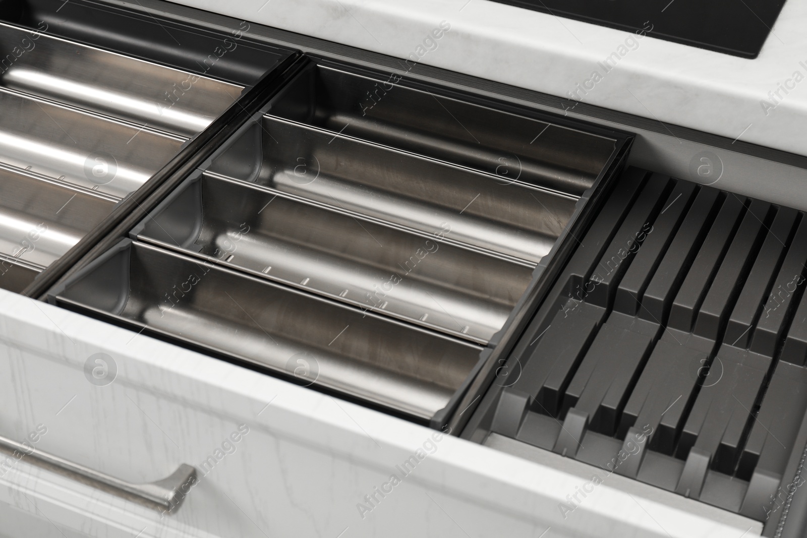 Photo of Open drawer of kitchen cabinet with space for cutlery, closeup