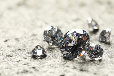 Photo of Many beautiful shiny diamonds on grey table, closeup