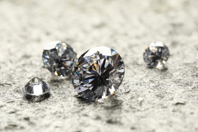 Photo of Many beautiful shiny diamonds on grey table, closeup