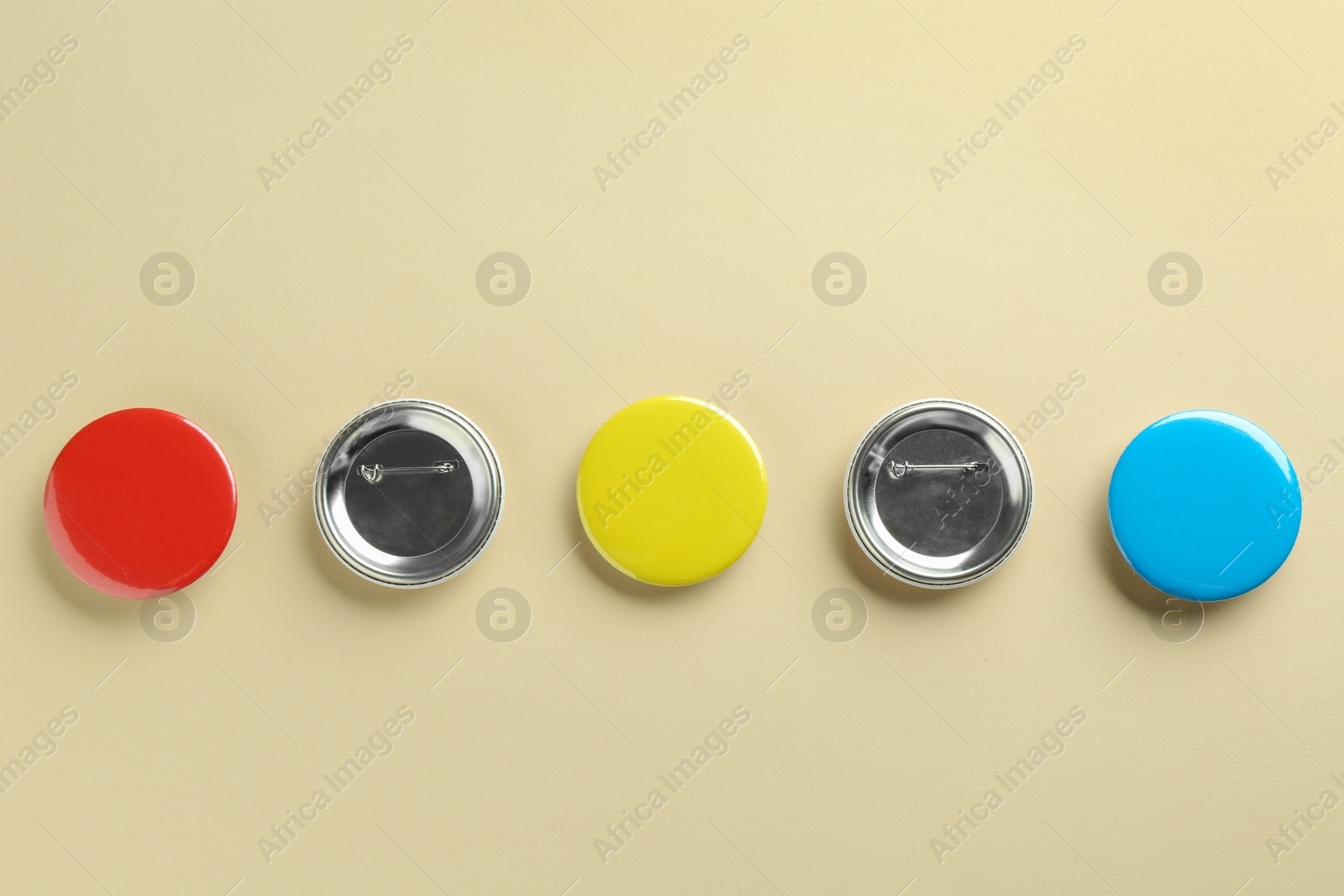 Photo of Colorful button badges on beige background, flat lay. Mockup for design