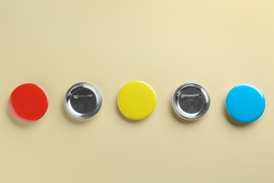 Photo of Colorful button badges on beige background, flat lay. Mockup for design