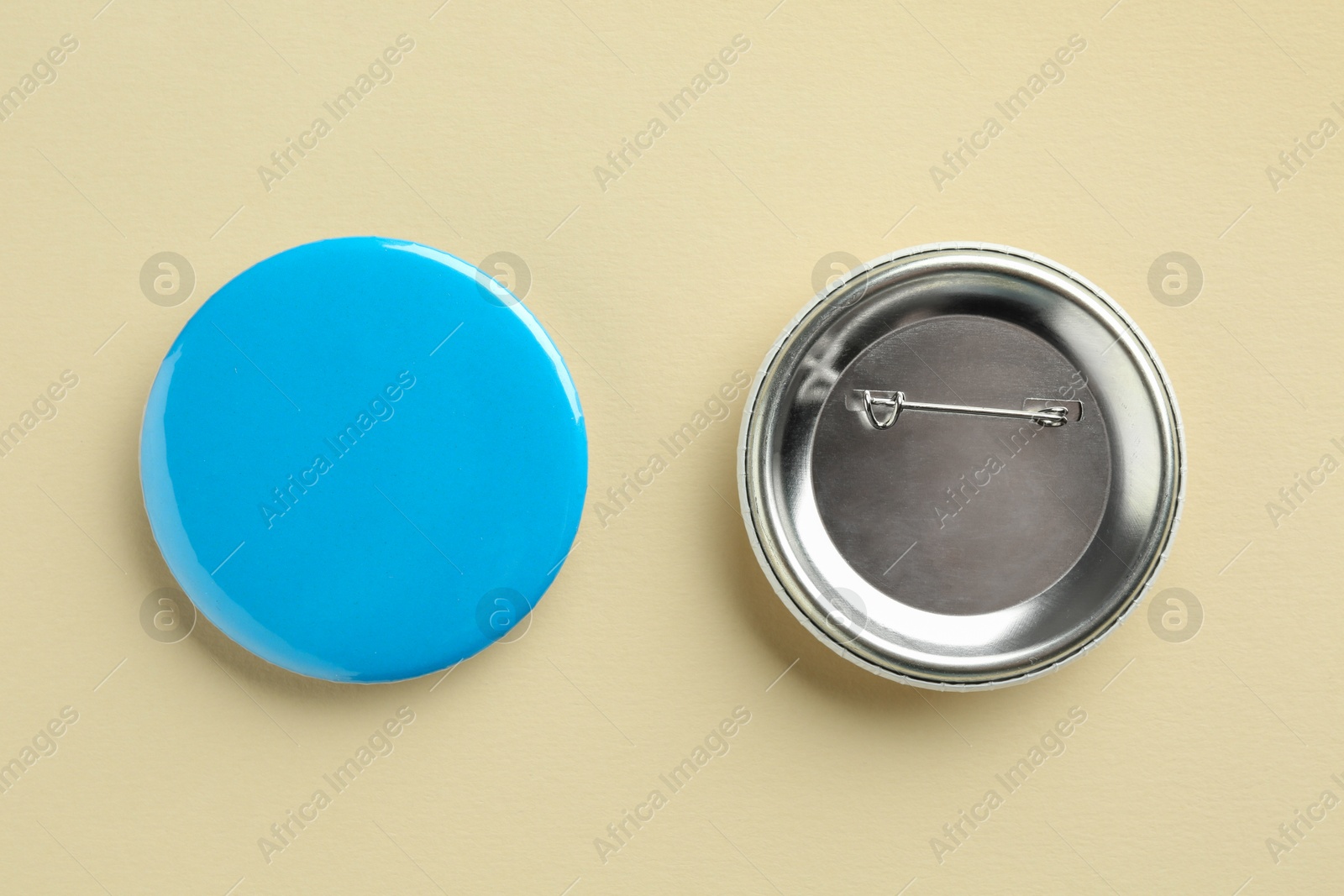 Photo of Button badges on beige background, flat lay. Mockup for design