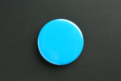 Photo of Blue button badge on black background, top view. Mockup for design