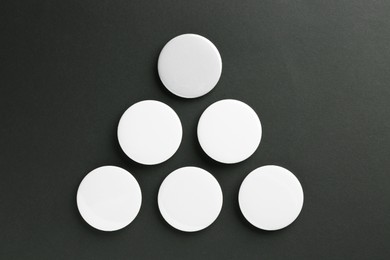 Photo of White button badges on black background, flat lay. Mockup for design