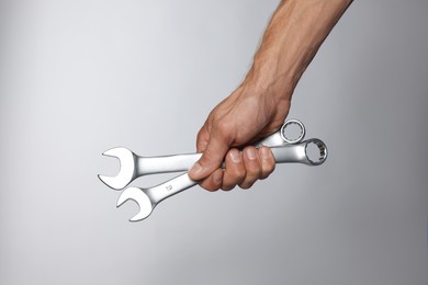 Photo of Auto mechanic with wrenches on grey background, closeup