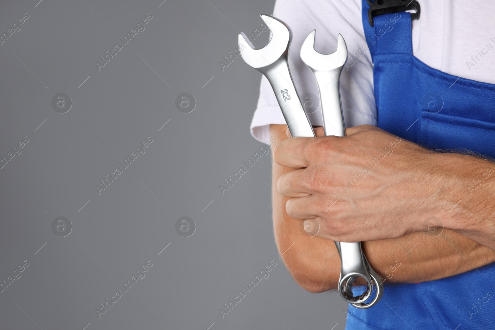 Photo of Auto mechanic with wrenches on grey background, closeup. Space for text