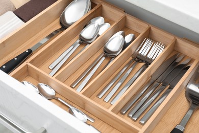 Photo of Box with cutlery in drawer, closeup. Kitchen utensils storage