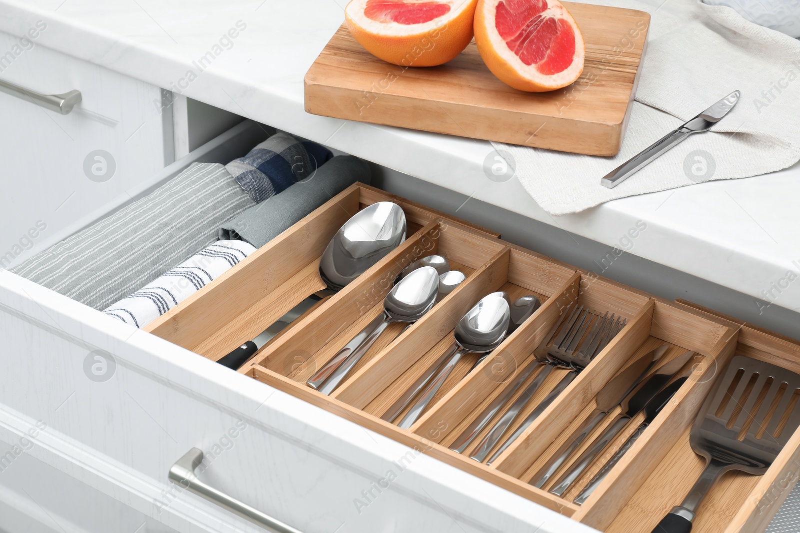 Photo of Box with cutlery in drawer, closeup. Kitchen utensils storage