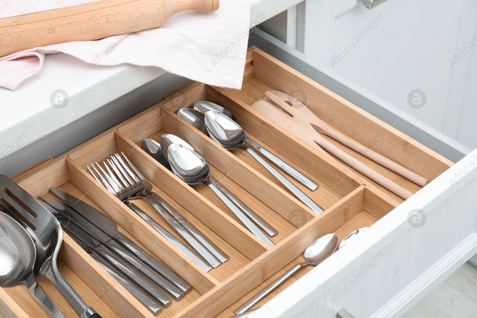 Photo of Box with cutlery in drawer, closeup. Kitchen utensils storage