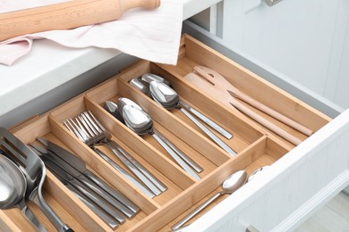 Photo of Box with cutlery in drawer, closeup. Kitchen utensils storage