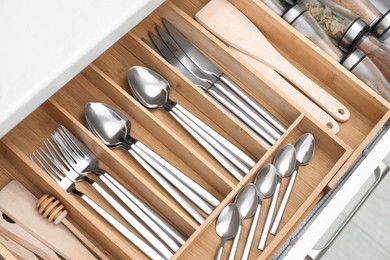 Photo of Box with cutlery in drawer, closeup. Kitchen utensils storage